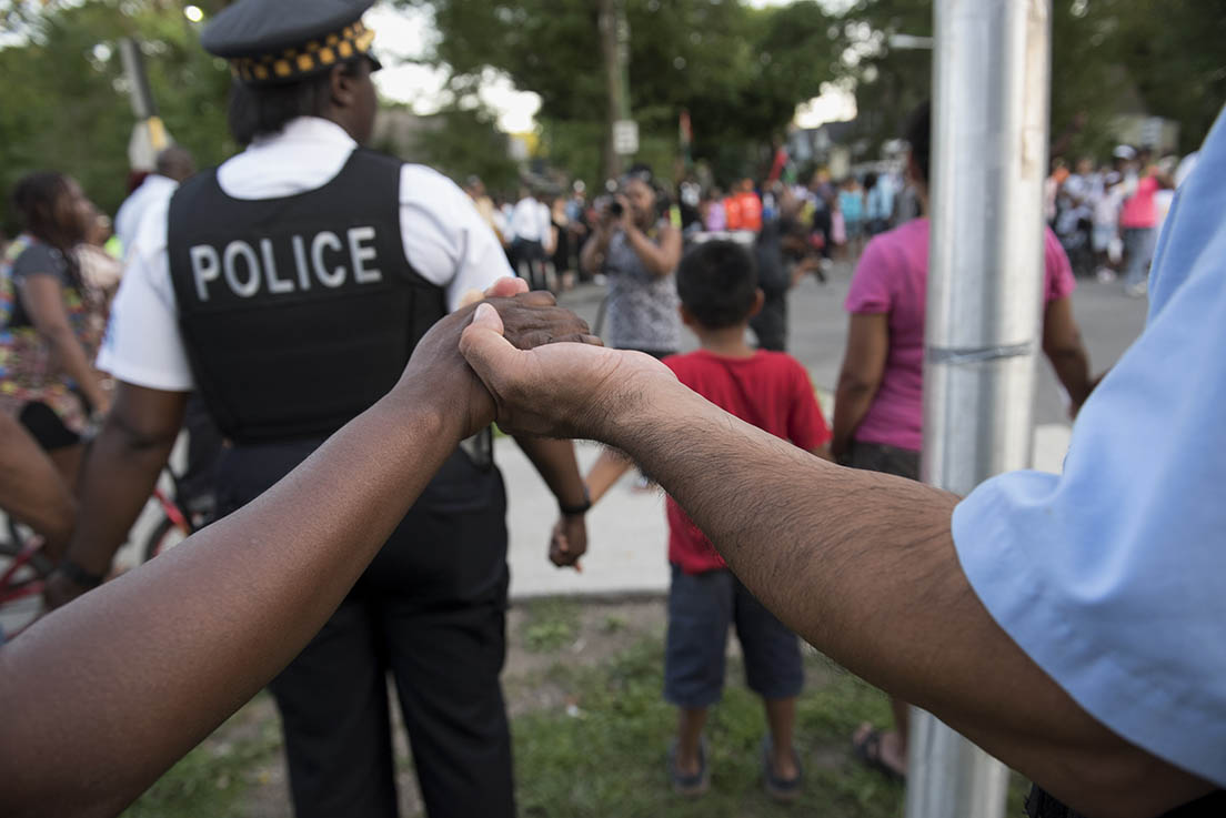 Image of residents and police officers of Chicago holding hands